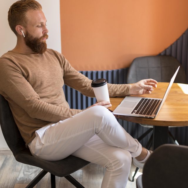 Homme barbu travaillant sur un ordinateur portable