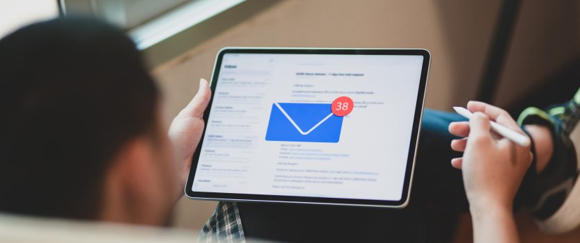 Jeune homme d'affaires vérifiant ses emails sur une tablette